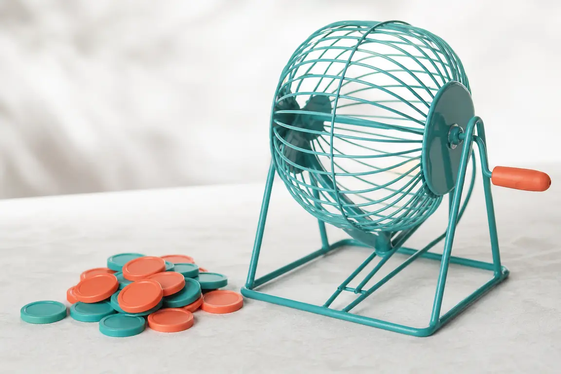 A small pile of plain unmarked tokens beside a reel drum.